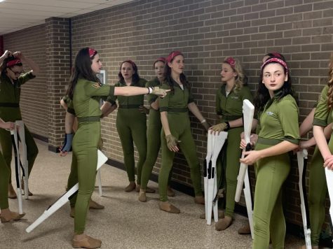 Grouping together before a team pep talk, the JV winter guard prepares to warm up for their first ever finals performance. This is the first time a JV winter guard program has advanced to finals at a regional competition in school history. (I liked) the experience of getting ready with everyone,” freshman Klarissa Warren said. “The excitement of getting ready with everyone before our performances was really great.” 
