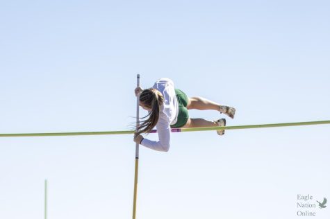 Leaping over the bar, senior Riley Perumal completes her pole vault event at the Dan Christie Relays track meet. Perumal placed fourth at the meet. Perumal will continue her pole vault career at the Naval Academy. 