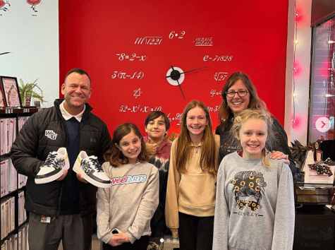 As he holds his new sneakers, the future principal of Walnut Grove High School, Dustin Toth, receives customized Walnut Grove Nike Air Force I shoes. Toth was gifted these shoes by future Wildcats. He visited the Mathnasium in Prosper.  The owner of Mathnasium is Jen Sanchez. 