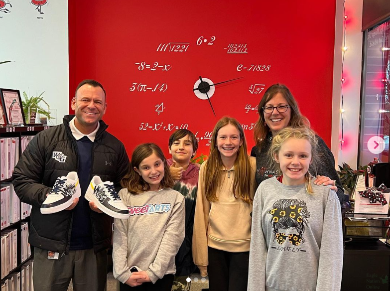 As+he+holds+his+new+sneakers%2C+the+future+principal+of+Walnut+Grove+High+School%2C+Dustin+Toth%2C+receives+customized+Walnut+Grove+Nike+Air+Force+I+shoes.+Toth+was+gifted+these+shoes+by+future+Wildcats.+He+visited+the+Mathnasium+in+Prosper.++The+owner+of+Mathnasium+is+Jen+Sanchez.+