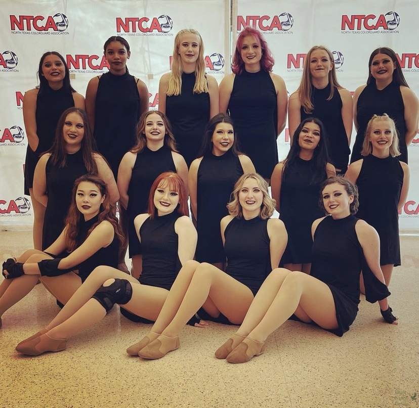 Following their final performance of the season, varsity winter guard members pose for a group photo in front of the North Texas color Guard Association (NTCA) backdrop. The team placed 5th at championships. Photographed (left to right, back to front) are Sammie Munoz, Mya Brim, Raegan Meyer, Kiera Payne, Makenna Boushey, Bella Koakoski, Adison Ewell, Addyson Bergman, Jayden Howeth, Camille Torres, Brinley Berkenbile, Kaylee Song, Sophia Adams, Megan Broyles and Nora Vedder