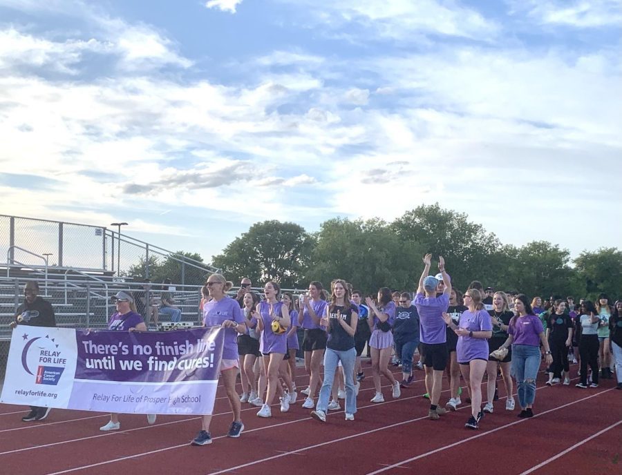 Walking+the+track+surrounding+the+practice+football+field%2C+participants+in+Relay+for+Life+start+their+lap+in+honor+of+cancer+survivors.+Survivors+hold+a+banner+that+reads+%E2%80%9CThere%E2%80%99s+no+finish+line+until+we+find+cures%21%E2%80%9D+Relay+for+Life+raises+money+for+the+American+Cancer+Society%2C+putting+money+towards+finding+a+cure+for+cancer.+