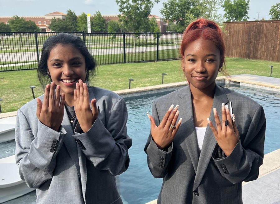 Hands raised in front of their faces, juniors Juliana Cruz and Samiya King check the contrast of their skin tones against their suits for a project for their American Sign Language class. The class requires distinct clothing, in order for people to comprehend hand signs. Students at Prosper are able to take the ASL course up to four levels.