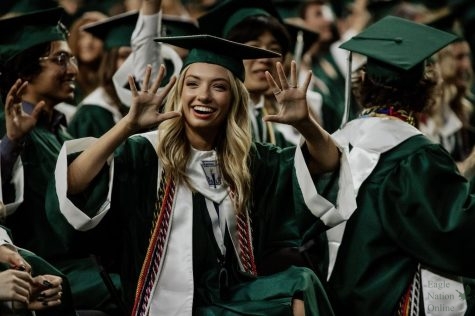 Hands in the air, senior Ava Anderson cheers after all seniors finished walking across stage. Anderson will be attending UT Austin in the fall. She received an invite to their spirit program, participating as one of the cheerleaders. 