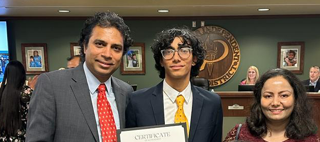 At the district office, senior Ethan Binoy receives an award beside his parents. Binoy has been first in the 2023 class since his sophomore year. His father Binoy Jose and his mother Dhanya Jose expressed their praise for his achievement. 