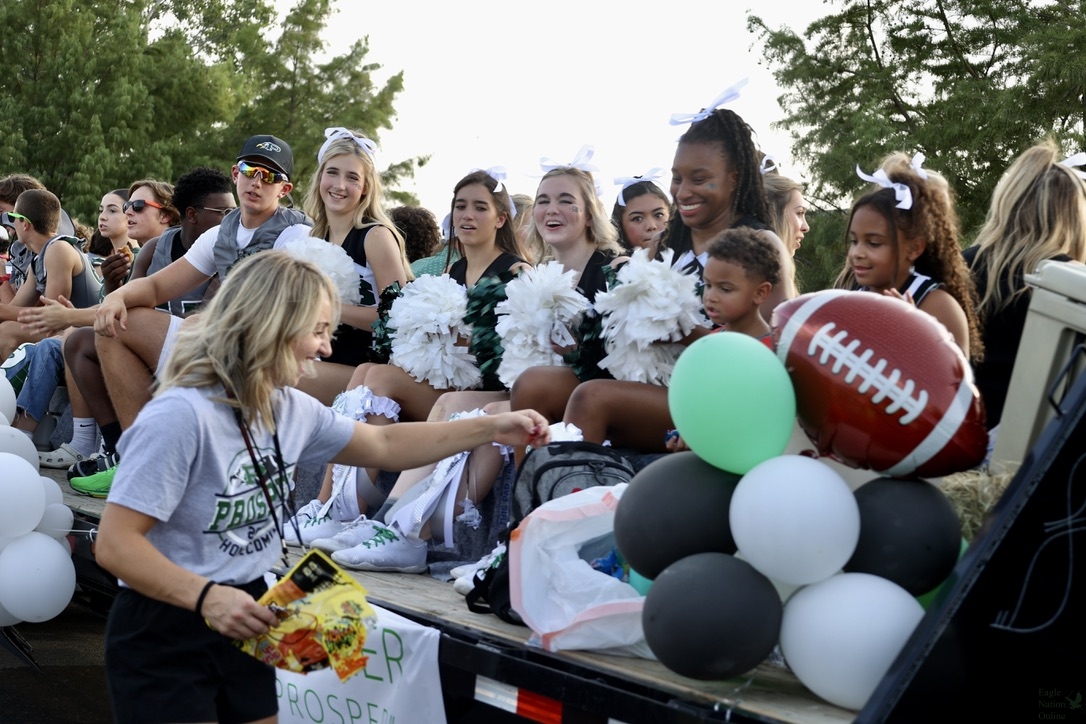 As they cheer on the crowd, the senior varsity football team and cheerleaders pass by on their float. The varsity team played their first game against Trinity on Aug. 25. Tonight, they will play their second game against Sacshe at 7 p.m. at Childrens Health Stadium.