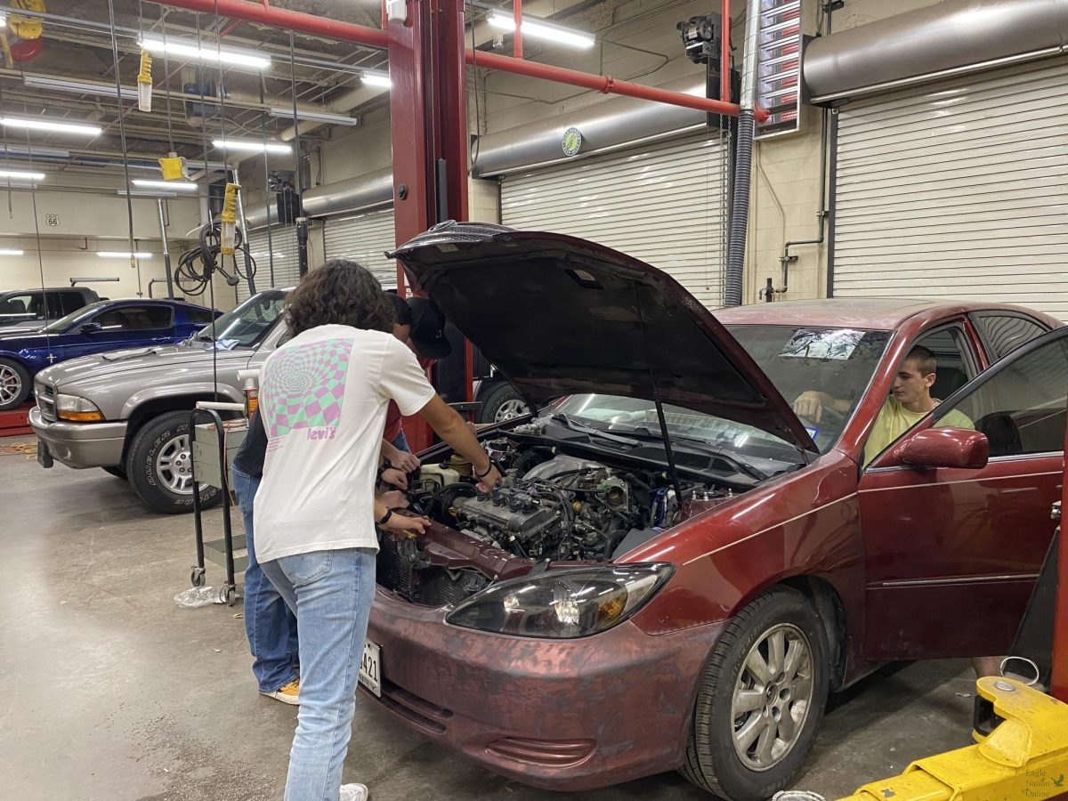 Leaning+over+the+engine%2C+senior+Tyler+Valencia+checks+under+the+hood+of+a+2002+Toyota+Camry.+Students+in+the+Automotive+Technologies+classes+work+on+different+vehicles+in+PHSs+garage.+Being+able+to+work+on+cars+throughout+the+school+day+is+an+amazing+way+to+learn%2C+Valencia+said.+Anybody+can+read+a+book+or+watch+a+video+on+how+to+do+the+things+we+do%2C+but+getting+to+actually+do+it+hands-on+helps+us+see+how+a+car+functions+when+under+different+situations.+And%2C+since+there+are+millions+of+different+cars+on+the+road%2C+theres+always+something+new+to+learn.