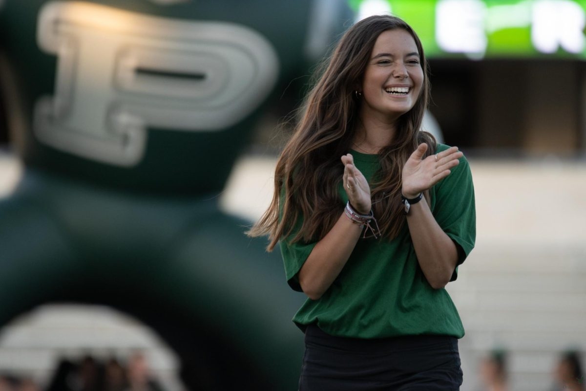 Clapping for her other teammates, senior Kiersi Bradley enters the field as part of the sports medicine program. Bradley is also on the tennis team. The nights event introduced the cross country, football, volleyball, swim and dive, waterpolo, tennis, Talonettes, band and cheer teams. 