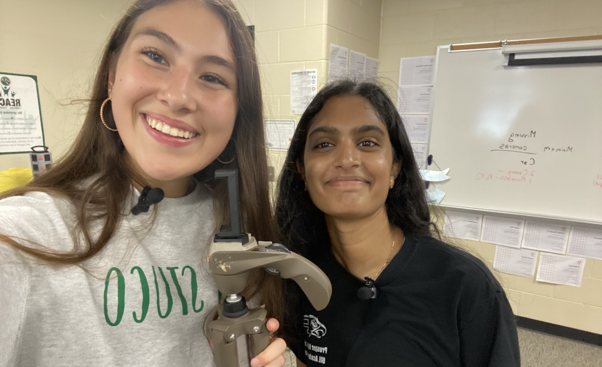 With tripod ready, senior Kaya Miller and junior Anisha Mandem finish up filming a school tour. Miller and Mandem filmed their trek for new students. A QR code  in the Student Guide print issue of Eagle Nation Times allowed readers to see the video via Eagle Nation Online.