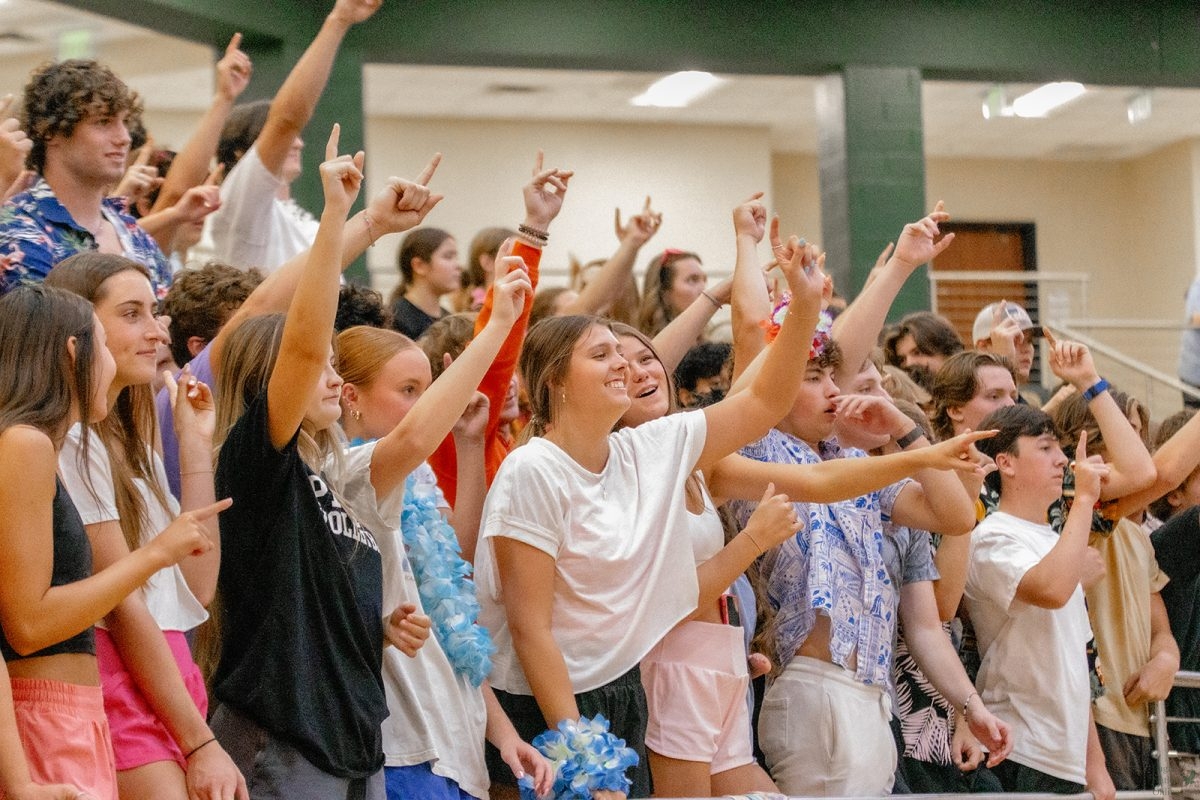 Hand raised in the air, holding up a No. 1, senior Julia Whatley stands in line with her classmates, cheering on the team. The Eagles played Decatur High School at home on Tuesday, August 22. The team will play again Sep. 1 against Arlington.