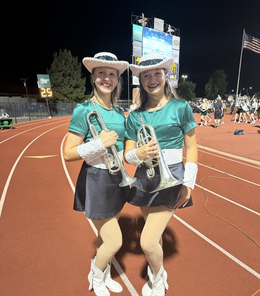 In their Talonettes uniforms, sophomores Abigail McGregor and Katie Lynn stand with the band at the Rockwall football game. McGregor and Lynn sit and play with the band during the game but perform with the Talonettes during halftime. The Prosper football team lost this non-district matchup, 47-41.