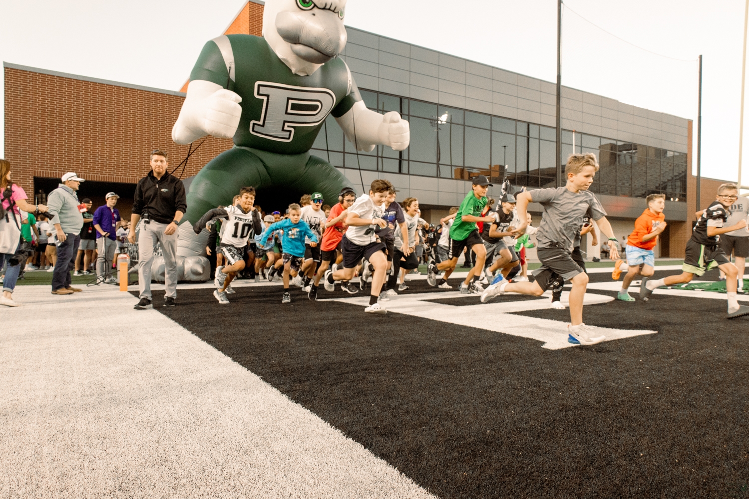 Charging down the field, the Prosper Flight Crew makes their way out of the tunnel. Every student involved in the program is assigned a football player to be their buddy for the game. Players exchange letters with the kids, and attend games throughout the year to support them. 