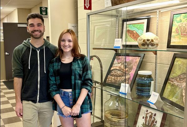 Standing next to a display showcasing various herpetological items, Collections Manager Greg Pandelis guides senior Lauren Clayton on a tour of UTAs Amphibian and Reptile Diversity Research Center. This facility holds the largest collection of reptiles and amphibians in Texas. Scientists all over the world gather data from this center and use it for conservation efforts.