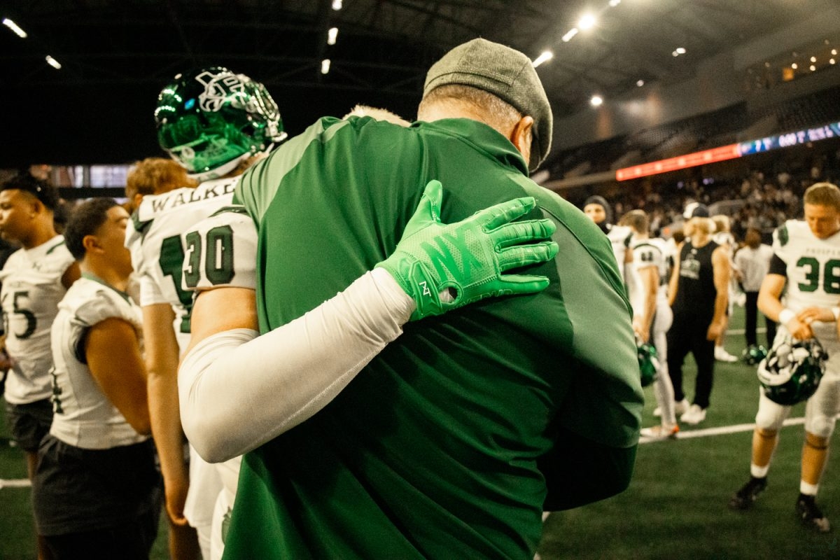 Arm wrapped around Coach Darrin Kight, senior Davis Perkins mourns the end of his season. It was special watching Davis get close with his coaches and teammates over the past few years, said senior Alexis Kirksey. Watching him from the student section was always so fun.