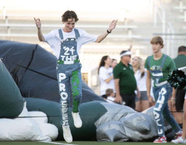 Wearing a cross country shirt under his overalls, senior Max Miller is introduced as a spirit leader at Meet the Eagles. Miller made it to UIL State Cross Country Championships for the third year as a Varsity Elite athlete. He also is a pianist and Spanish Honor Society vice president. 