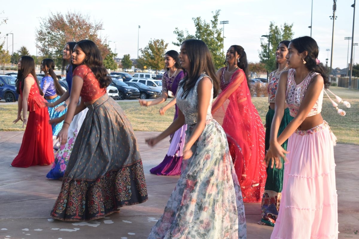 With Bollywood music playing, freshman Tanushri Vijayakumar leads members of the Bollywood Dance Club. The group performed many dance routines at the Diwali celebration, hosted Nov. 18 by the Indian Student Association at Frontier Park. Us Indians love expressing ourselves through our moves and how we do stuff, sophomore Anish Moilla, president of the Prosper Bollywood Dance Club, said. So, dance and music is one of our favorite ways to get out there and enjoy ourselves.