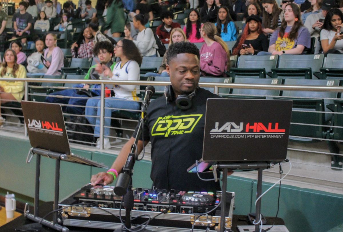 As he looks at his laptop, DJ Jay Hall focuses on making the next selection for the pep rally. Hall is a DJ for hire at DFW Pro DJs. He made an appearance at the winter sports pep rally on Feb. 9.