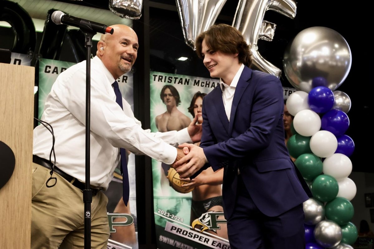 Shaking hands with the diving coach, sophomore Pierce McHam received the Best Diver Award. Some teammates recieved awards for their performance throughout the year as a player and as a teammate. The banquet took place in the community room at Childrens Health Stadium.