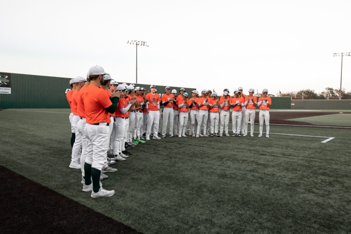 Joined+by+the+Prosper+and+Rock+Hill+varsity+baseball+teams%2C+Jaxson+Little+stands+on+the+PHS+field.+Prior+to+game+time%2C+the+teams+recognized+Little+and+his+journey.+Both+teams+wore+orange+during+pregame+for+both+games%2C+in+honor+of+Little.