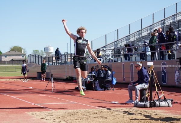 About to land, senior Nathan Tenbarge competes in the long jump event. Tenbarge played quarterback for the football team during track off-season. He placed sixth in his event. 