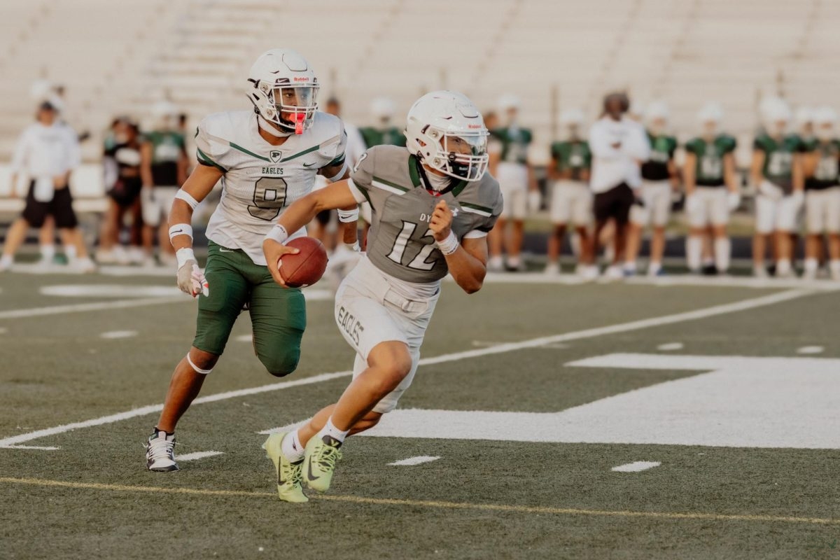 Eyes on the field, sophomore Tyler Albert runs with ball in hand. This is Alberts first year on varsity. Both junior varsity games played beforehand. The varsity green team won against the white team. The first game will be on Aug. 29 against Austin Westlake. 