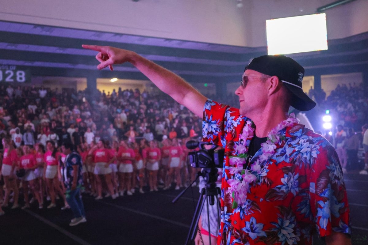 On the Arena floor, Principal Nicholas Jones points to the junior section during a pep rally. The first pep rally of the year was aloha-themed and took place Aug. 23. “I love the alma mater and the fight song,” Jones said. “It’s my favorite part of the pep rally every time.”