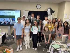 With their newspaper on the board behind them, members of the staff of Eagle Nation Online and Eagle Nation Times showcase a message from Superintendent Holly Ferguson. These students met four times over the summer to meet each other, learn new journalistic skills and plan and prepare for the coming school year. Seen in the photo, from left to right, are freshmen Eli Deutsch and Ethan Chatelain, senior Erica Deutsch, freshman Max Allen, seniors Sofia Ayala and Jake Radcliffe, sophomore Srihitha Madepalli, senior Justin Wang, junior Emily Logan, freshmen Ava Ruhter, Michelle Ayala and Polly Greaves and juniors Trisha Panicker and Aarushi Rana. 