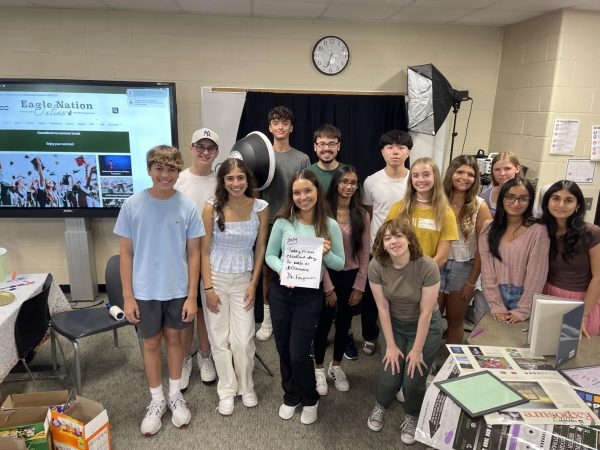 With their newspaper on the board behind them, members of the staff of Eagle Nation Online and Eagle Nation Times showcase a message from Superintendent Holly Ferguson. These students met four times over the summer to meet each other, learn new journalistic skills and plan and prepare for the coming school year. Seen in the photo, from left to right, are freshmen Eli Deutsch and Ethan Chatelain, senior Erica Deutsch, freshman Max Allen, seniors Sofia Ayala and Jake Radcliffe, sophomore Srihitha Madepalli, senior Justin Wang, junior Emily Logan, freshmen Ava Ruhter, Michelle Ayala and Polly Greaves and juniors Trisha Panicker and Aarushi Rana. 