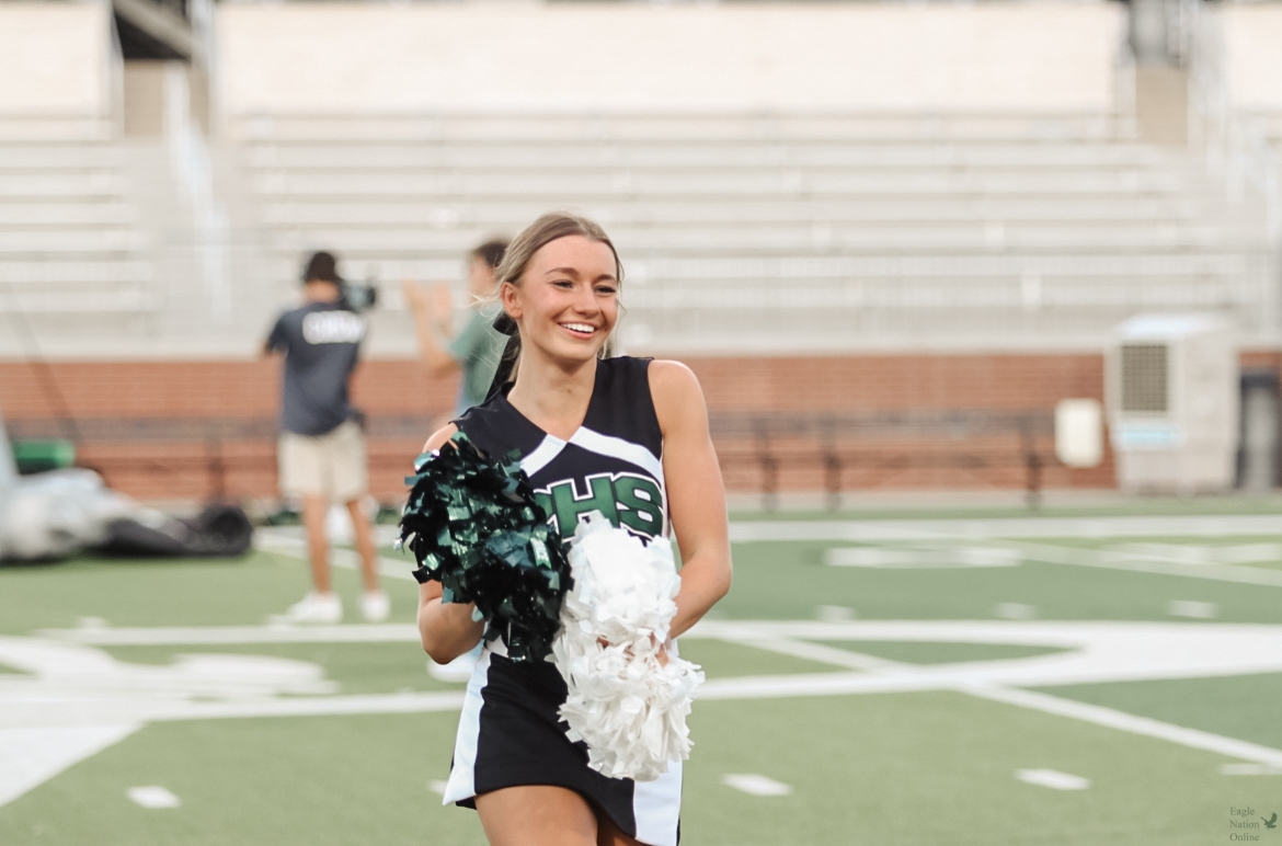 As she looks into the crowd, senior Haylee Alexander cheers alongside the Prosper Varsity cheerleaders. This is her fourth year in the program. Alexander also has cheer experience outside of school. 