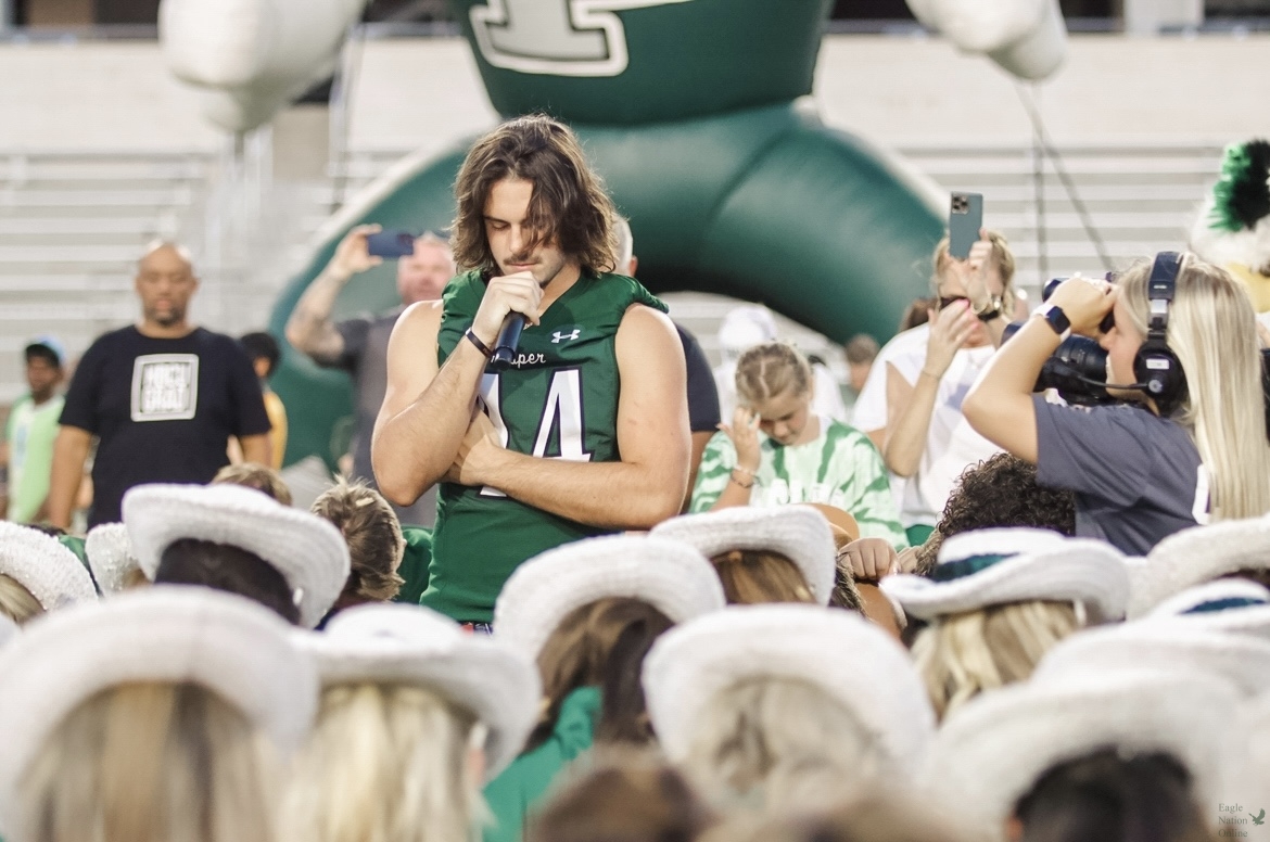 Head bowed, senior Tayvin Labbe leads Children's Health Stadium in a closing prayer. This will be Labbe's second year on the varsity football team. "I really wanted to use this prayer to ask God to not only watch over our student athletes," Labbe said, "– but Prosper as a whole."