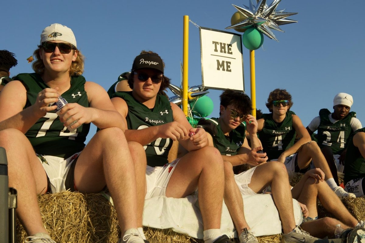 Junior Lathon Latiolais (second from right) sits with his teammates during the annual parade. The PHS varsity football float was built as a pirate ship to represent Prosper High School being the "flagship" school within PISD. PHS is often referred to as "The Ship". 