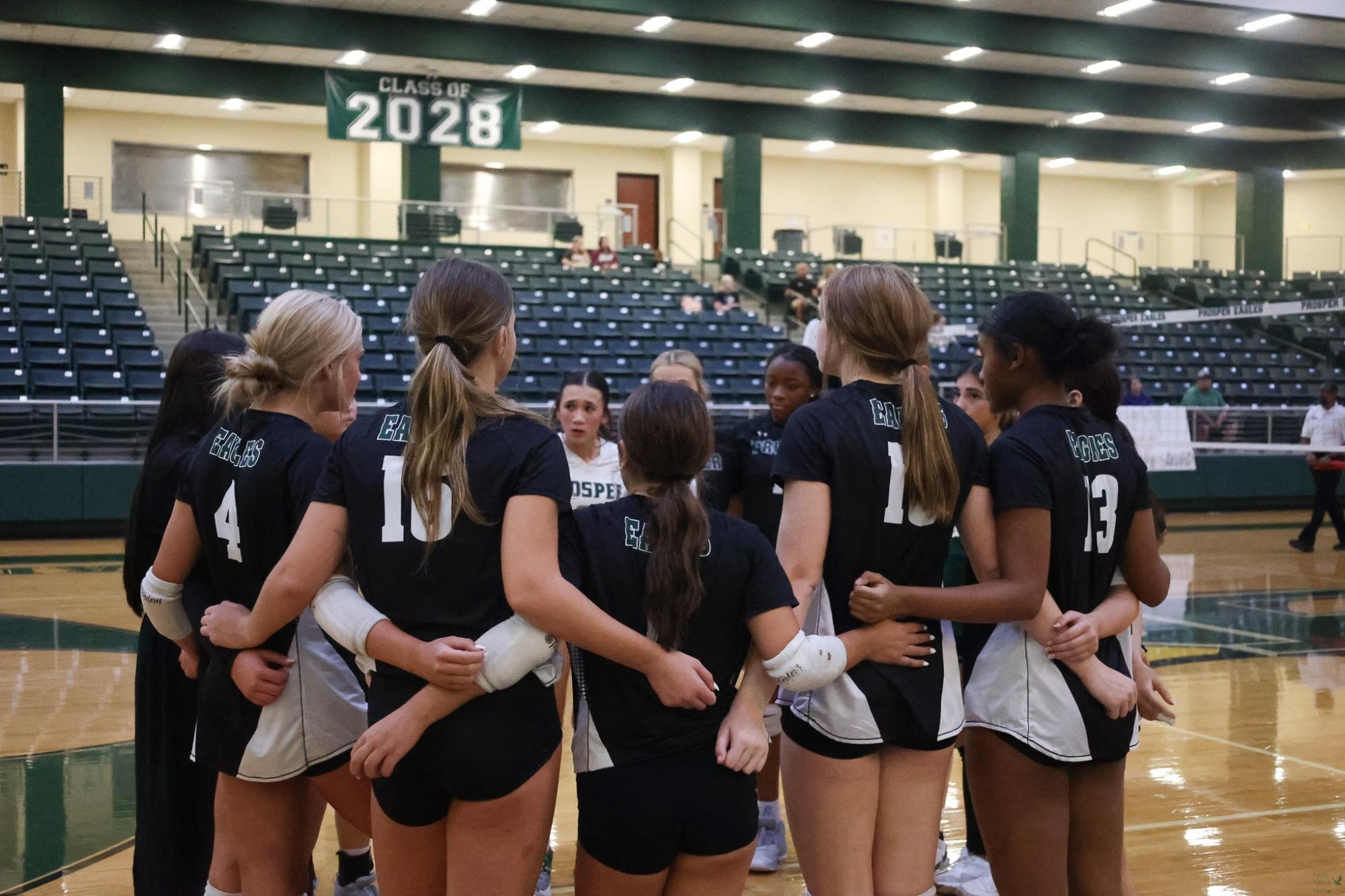 On the court, the junior varsity volleyball team huddles with their coach during a timeout. The Lady Eagles swept Princeton High School 3-0. “Everything I love about volleyball is getting to know the kids and helping them grow,” varsity assistant coach Mary Beth Spinuizzi said. “Not only in skill, but in character, on and off the court.”