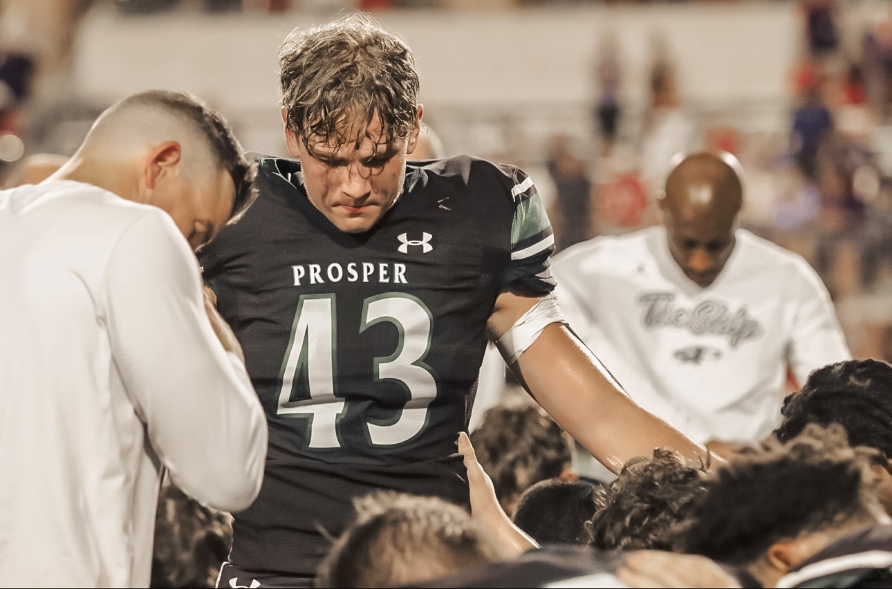 Head bowed, junior Justin Alfano leads the team in prayer after the game. Alfano plays as the second string quarterback. "I thought it was great I was able to be a part of my team and lead the team in prayer because I like to share my faith in every way I can and spread His name, word, and gospel," Alfano said. "Being able to do that with my team made me really happy."