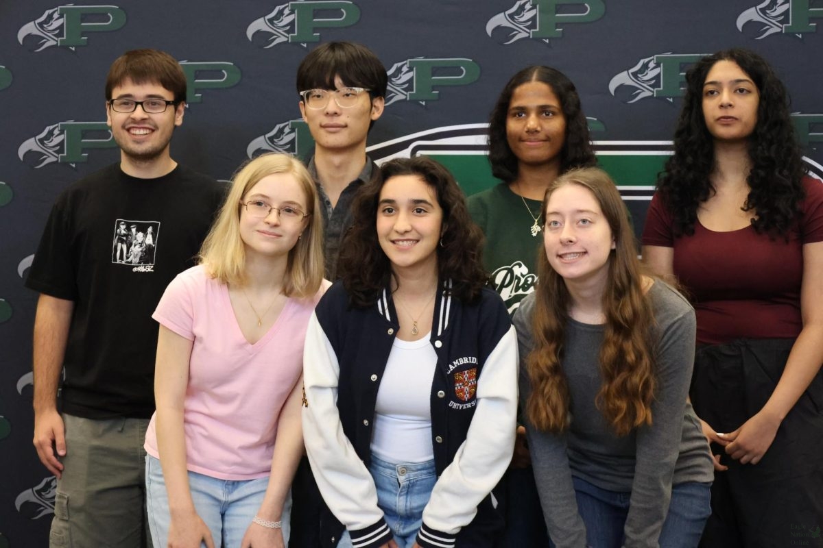 At a photoshoot, National Merit Scholarship semifinalists stand together. These students were chosen for this award based off of their PSAT scores. Pictured in this photo, from left to right, are seniors Jake Radcliffe, Savannah Williams, Isaac Lee, Mara Gonzalez Moral, Niva Malthankar, Chloe Phillips and Hima Abilash.