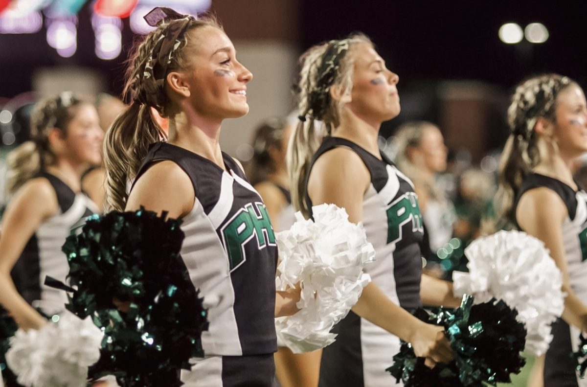 Poms out, senior Haylee Alexander cheers towards the crowd. The Cheerabilities program, a cheer team for special need students, joined the team on the sidelines at Friday's game. "My favorite part of Friday's game was definitely helping with Cheerabilities," Alexander said. "I love those girls and they just make our games so much better."