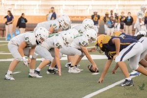 Hand on the ball, no. 63 freshman Drew Alderton prepares to snap the ball to the quarterback. This is Alderton's first year playing center in the football program. This marked the fifth home game. 