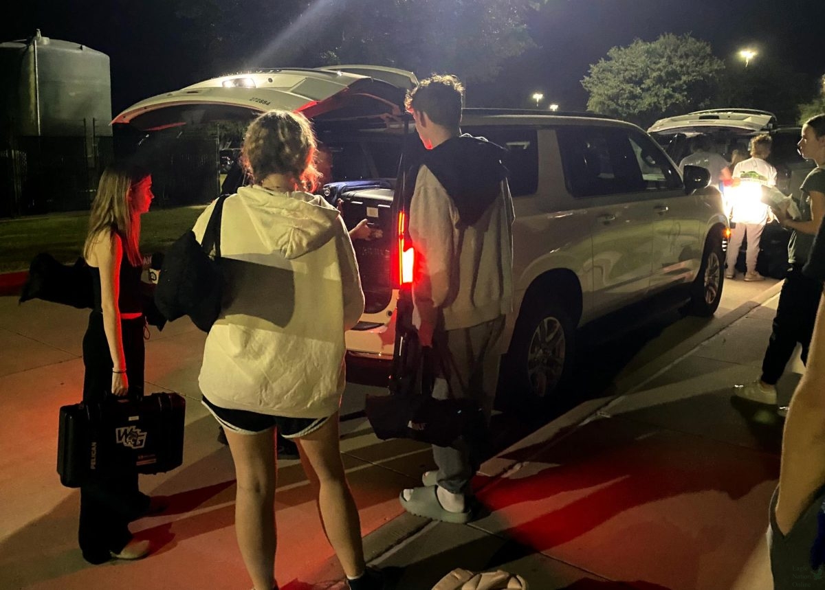 Outside the school at 5 a.m., juniors Madison Koepp, Nuala Adams and Landon Byrom pack their equipment into a district travel car. Broadcast and newspaper students traveled to San Antonio for the TAJE Fall Fiesta convention Oct. 14. New district travel guidelines restrict CTE, Fine Arts and Academic Competition groups' ability to travel.