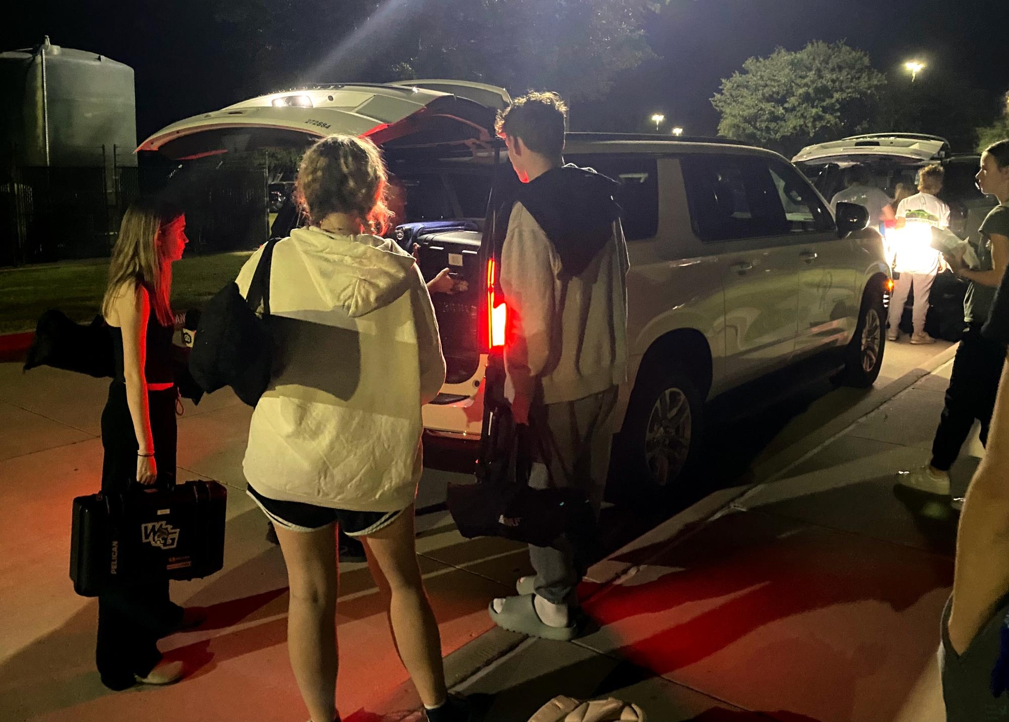 Outside the school at 5 a.m., juniors Madison Koepp, Nuala Adams and Landon Byrom pack their equipment into a district travel car. Broadcast and newspaper students traveled to San Antonio for the Texas Associatin of Journalism Educators Fall Fiesta convention Oct. 14. New district travel guidelines restrict CTE, Fine Arts and Academic Competition groups' ability to travel.