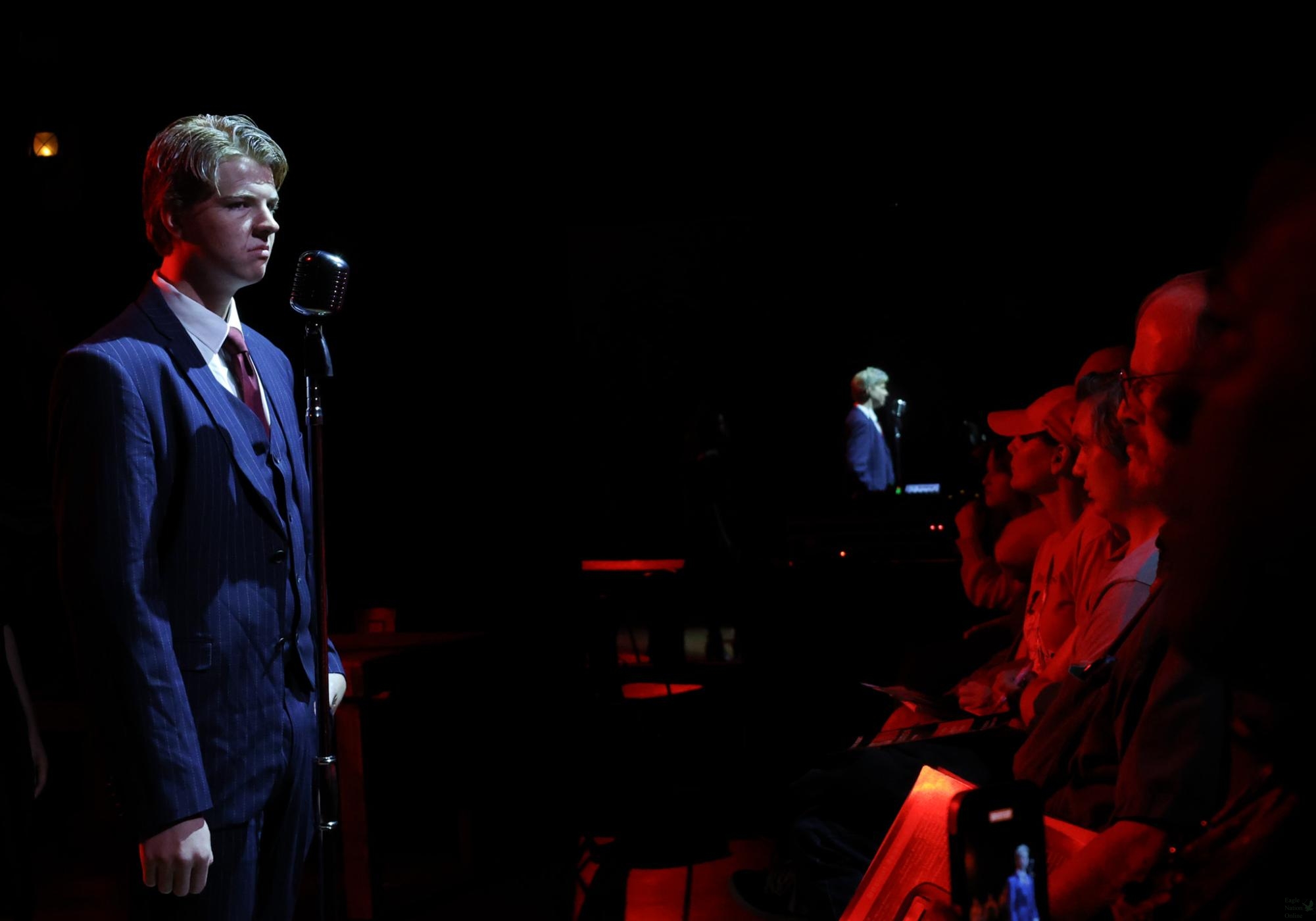 While the audience watches, junior Boyd Mueller sings into a microphone. Mueller plays Hades. Prosper Theatre's "Hadestown: Teen Edition" was chosen to be performed at the Main Stage at the Texas Thespian State Festival in Grapevine. "Generally, Main Stage is a privilege almost exclusively given to private fine art schools," stage manager senior Annabelle Nugent said. "The fact that a public school like Prosper is getting Main Stage is fantastic. Simply, it means that we are at the level of schools who specifically draft for stuff like fine arts and singing and dancing ability, and it's really a compliment to our actors and our technicians."