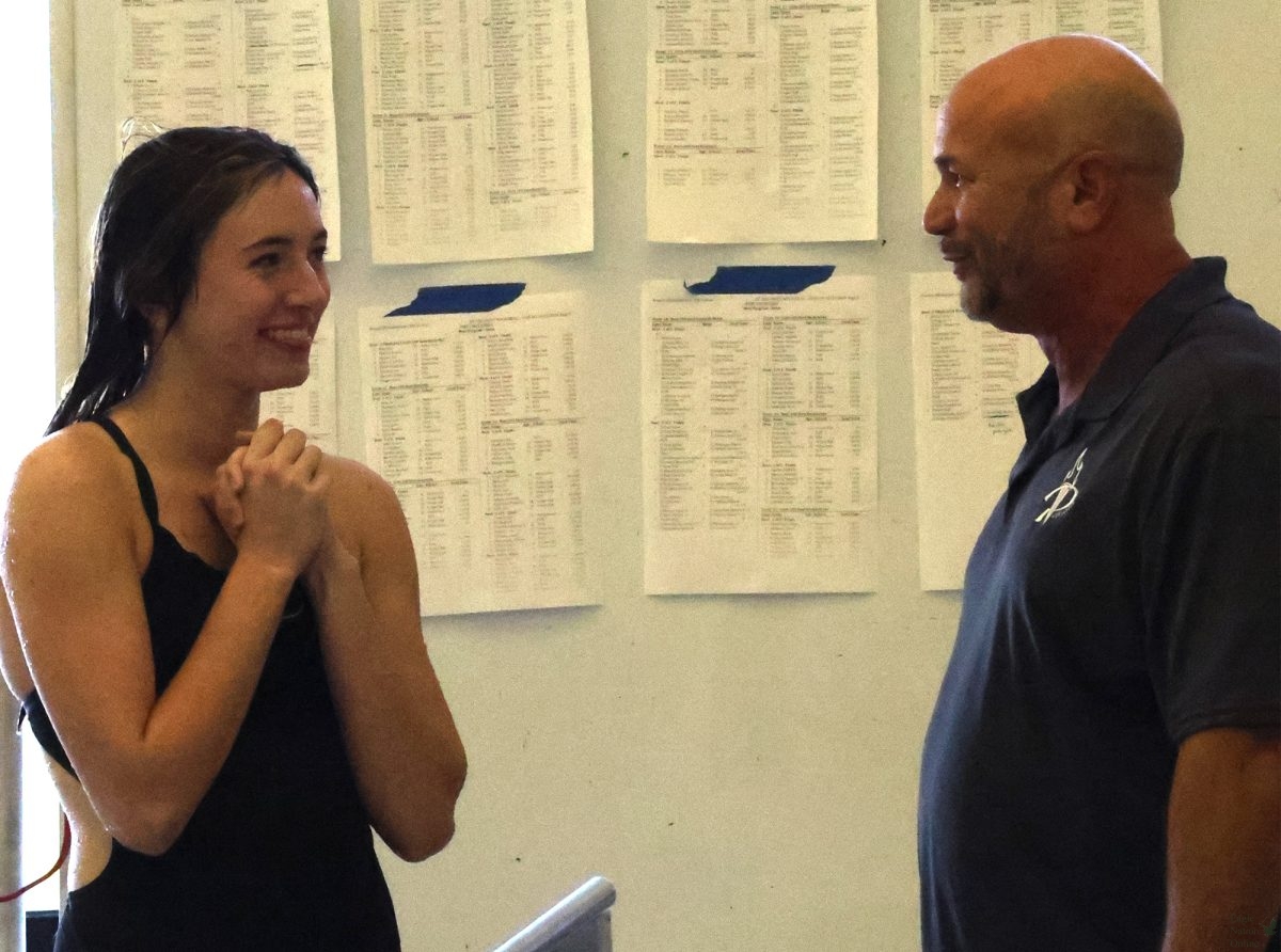 As they discuss a dive, junior Kiera Williams listens to dive coach Eric Ognibene. Williams competes in varsity water polo, varsity swim and varsity dive. "You can't be scared and be a diver," Williams said. "You have to just do it."