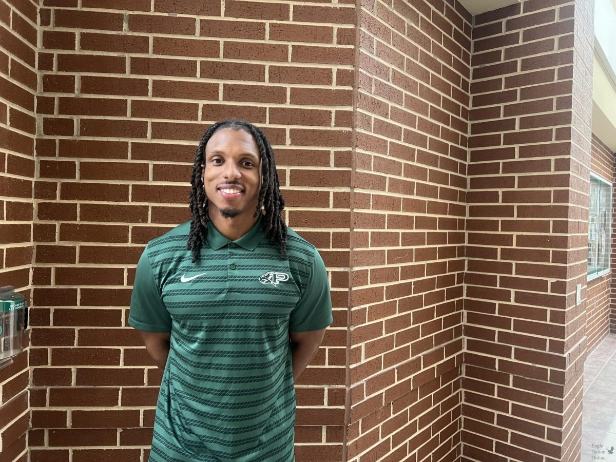 Standing in green Malcom Hill continues his passion for football as a coach. This marks his second year working for Prosper High School. "I kind of fell in love with the sport in middle school," Hill said. "Played it throughout high school and up until college.” 