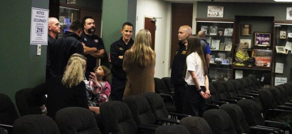 Standing together, Prosper paramedics and attendees engage in conversation before the meeting starts. These paramedics were invited to the meeting to receive the Life Saving Award as they played a vital role in saving Dr. Greg Bradley's life.