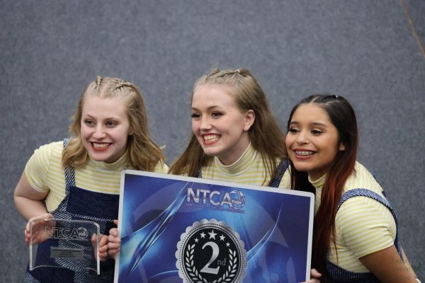 Holding their trophy and placement card in hand, seniors(from left to right) Brinley Berkenbile, Makenna Boushey, and Samantha (Sammie) Munoz smile after retreat. Varsity Winter Guard placed second in the Regional-A NTCA competition. In their most recent competition they we're third in the WGI Tulsa Regional.