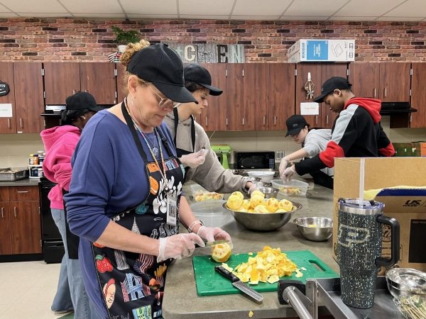 Knife in hand, culinary teacher Sonja Kabell slices an orange in preparation for the culinary arts program's next catering event. Alongside Kabell, sophomores Katia Ramos, Morgan Sweat, Jiyoon Lee and Christian Lee assist in the process. “Our catering company, Eagle Eatery, is essentially student-run," Kabell said. "They’re making everything from scratch, from fruit kabobs to hasbrowns, and they handle service directly. It’s a professional-level experience.”
