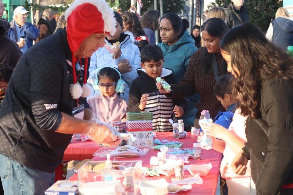 At Prosper's annual Christmas Festival, a volunteer helps families decorate holiday-themed cookies. The event was held on Dec. 5, 2025 and lasted from 3-7 p.m. Some activities conducted at the festival include a selfie station with Santa, face painting, an ice skating rink and more. 