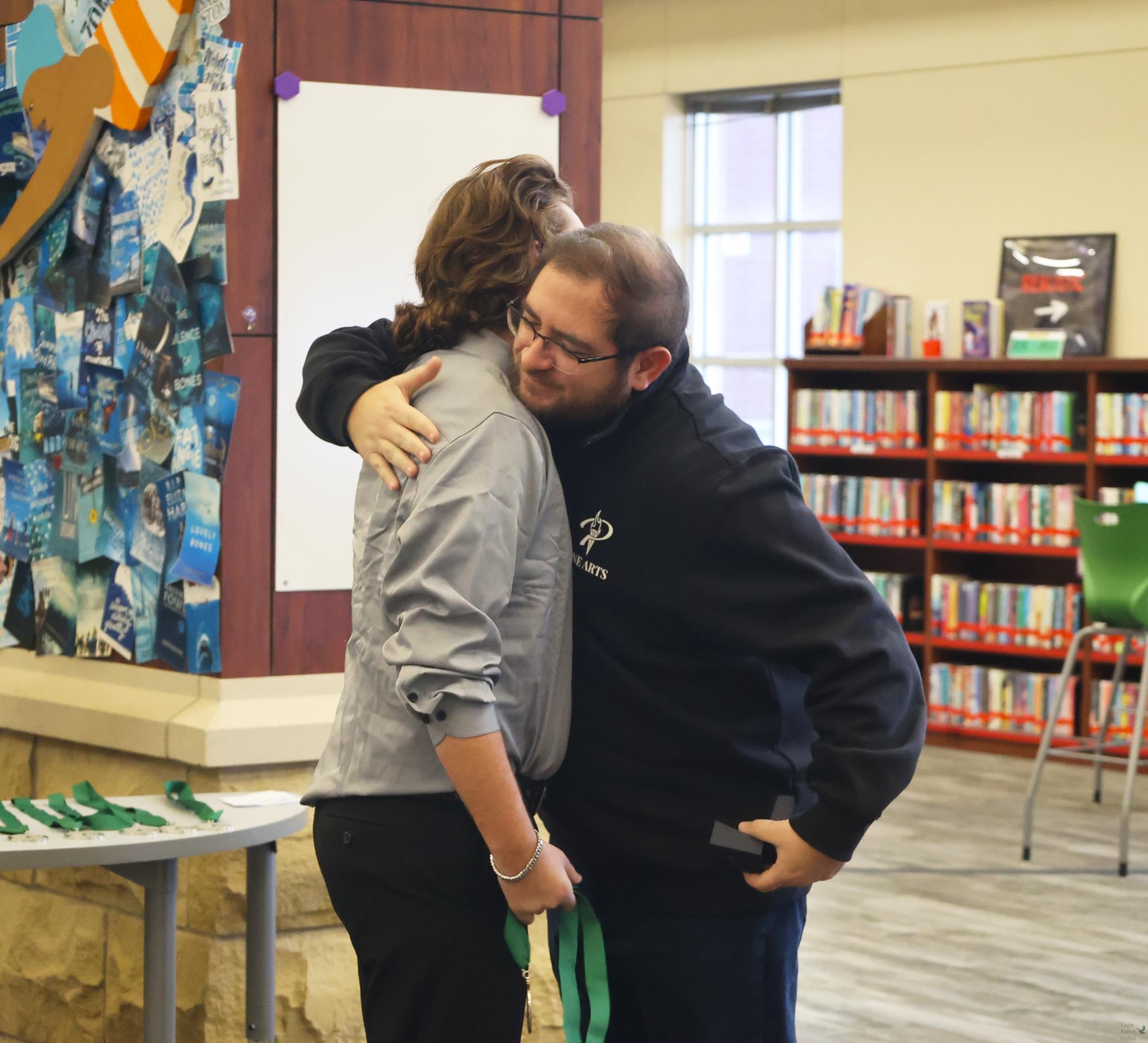 Together for an embrace, junior Peyton Butler and Head Band Director Aaron Rezenbrink hug after Butler's words were read. Butler honored Rezenbrink for helping him become a better marcher and musician. "I felt really good about being able to honor the teachers who have made commitments today," Butler said. "It was really nice."
