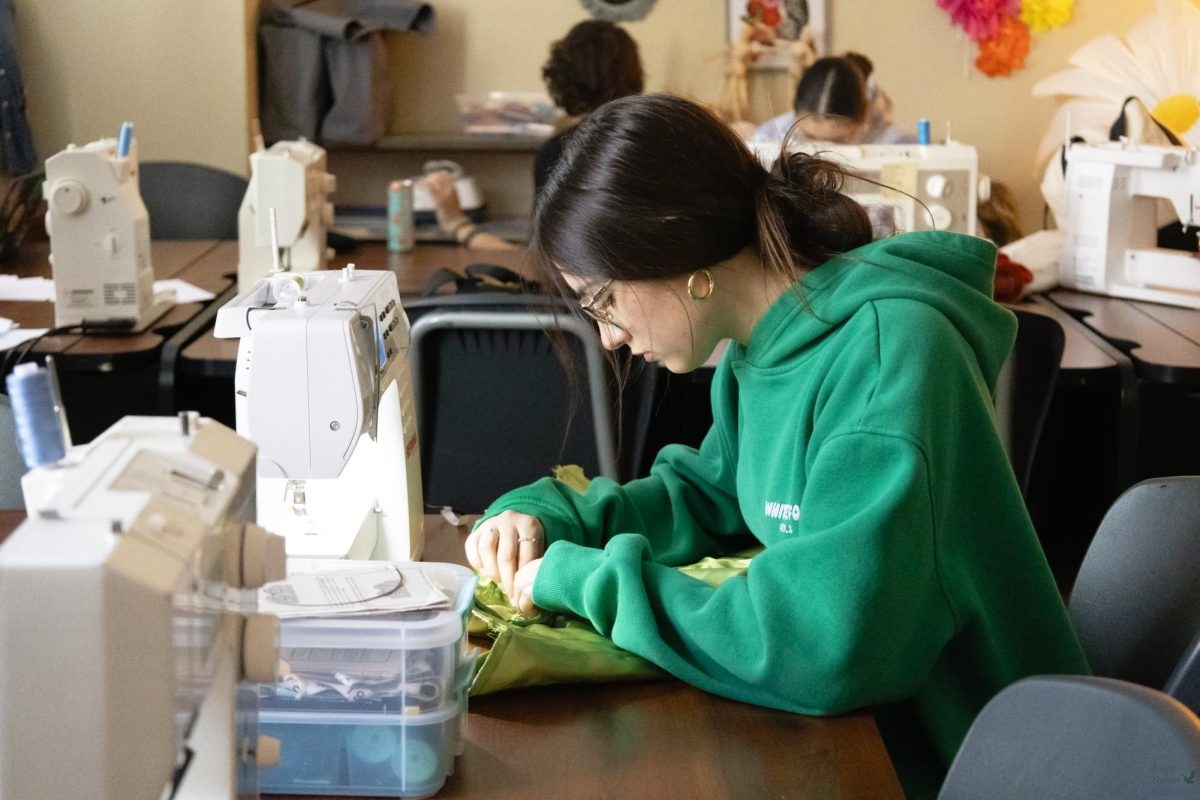 Weaving through fabric, senior Brittanie Green sews a green corset. Green is currently in the Fashion Design II class and practicum, a class centered around making different clothing pieces and hosting the fashion show later in the year. "I really like it," Green said. "You get to express your creativity and put that into clothes."