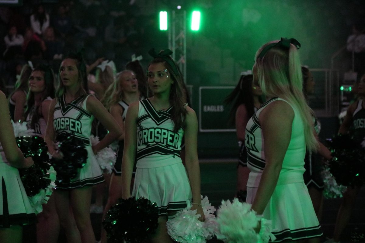 Looking off to the side, junior Jayda Pento waits to begin the performance. Pento is a flyer for the cheer team. The first pep rally of the year's theme was Space Jam.