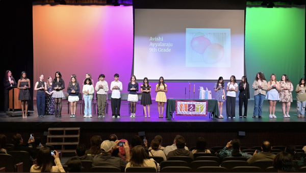 Holding candles, the new inductees of National Art Honors Society stand in front of the crowd. They were inducted on Thursday, Feb. 5. 32 new members joined this year.