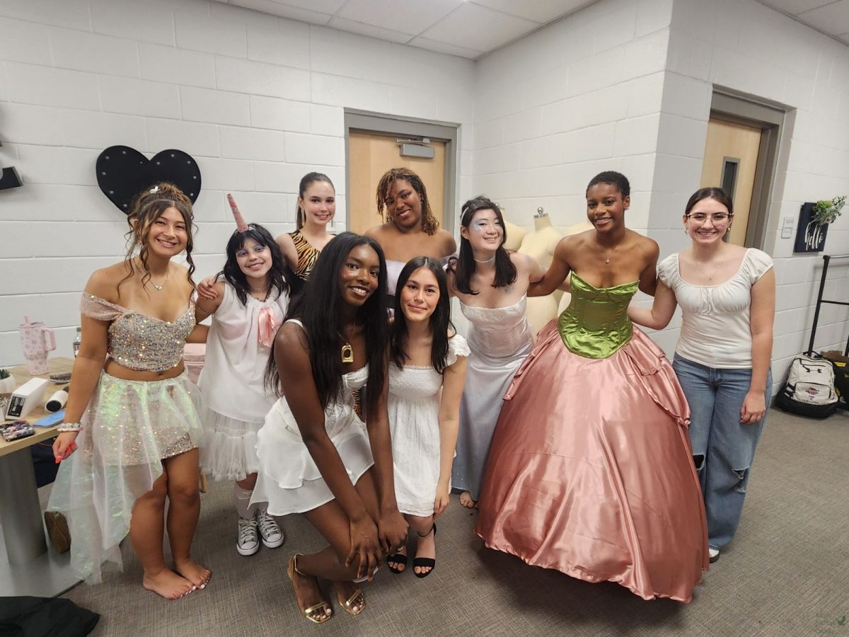 Huddled in their newest outfits, fashion design students prepare to go on stage. Pictured in the photo are student Jaiden Correia, Carolina Reyes, Cora Roberts, Khloe Koan, Lyn Lee, Gabby Jones, Brittanie Green, Samantha Owusu and Giana Ventura. The fashion show took place on April 13 at Walnut Grove high school. “Our fashion show is inspired by flowers,” Green said. “My dress is like a big flower. The bottom (is) the pink petals of a flower. I (felt) prepared, but starting this project and working through it and being done with it on time (was) really hard.”